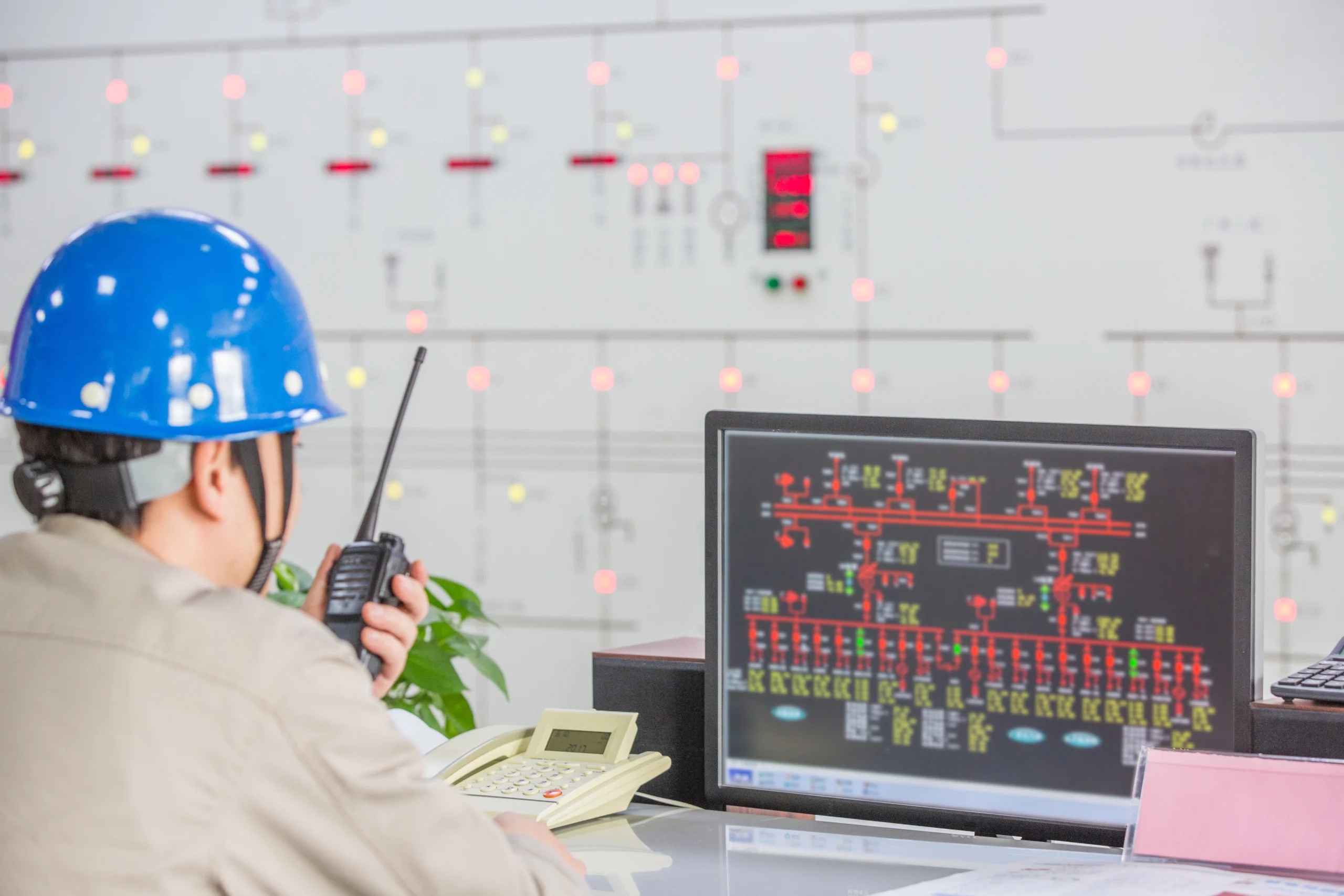مهندس در حال برنامه‌ریزی برای آینده سیستم‌های کنترل صنعتی در یک کارخانه مدرن.
