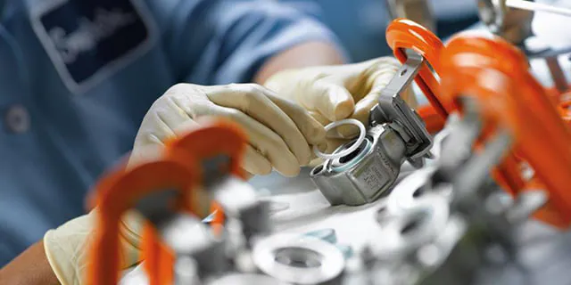 نمای نزدیک از یک زانویی فولادی با رزوه‌های مخروطی استاندارد NPT.
