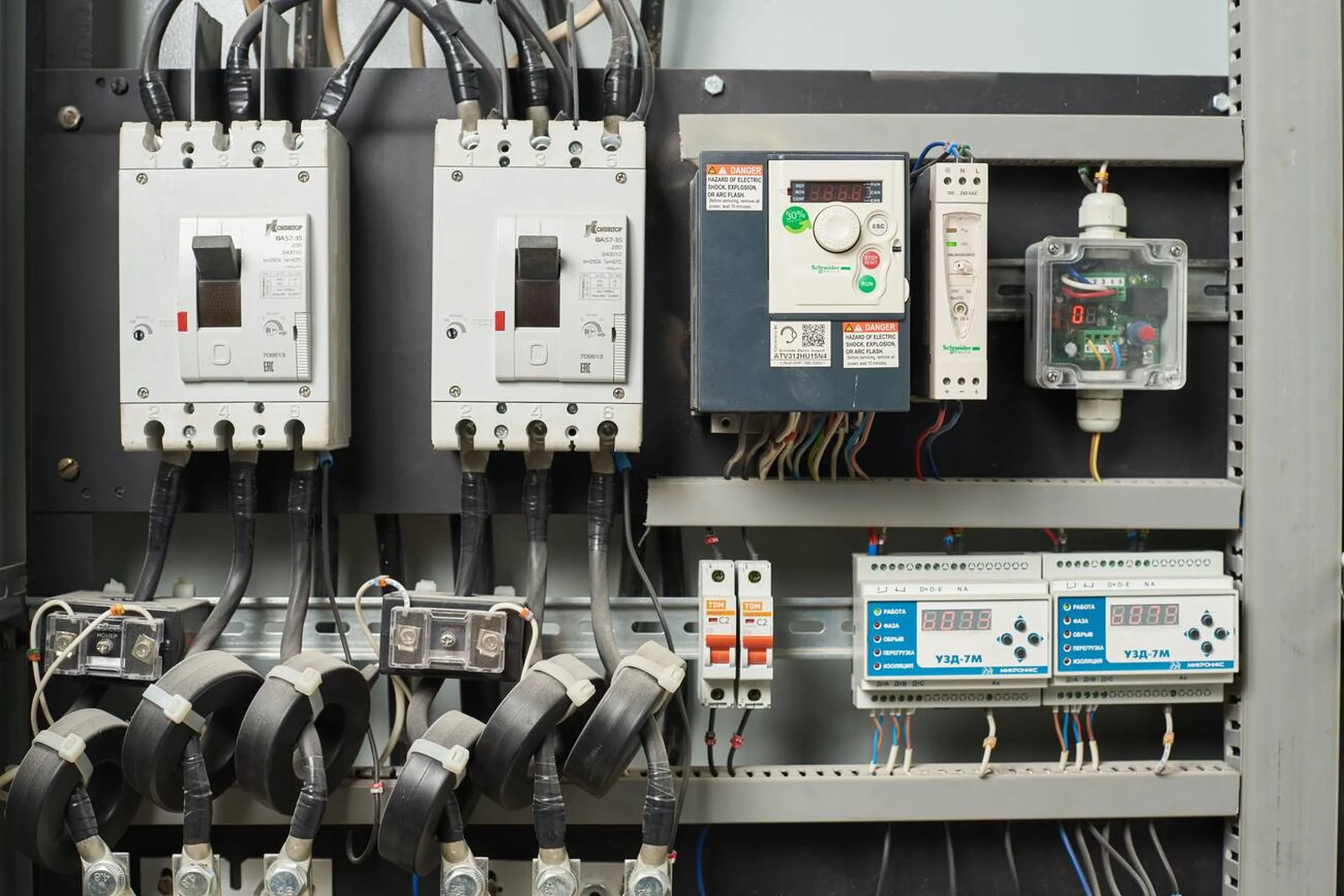 یک تکنسین در حال بررسی کابینت کنترل یک توربین بادی که شامل یک کنترلر PLC است.