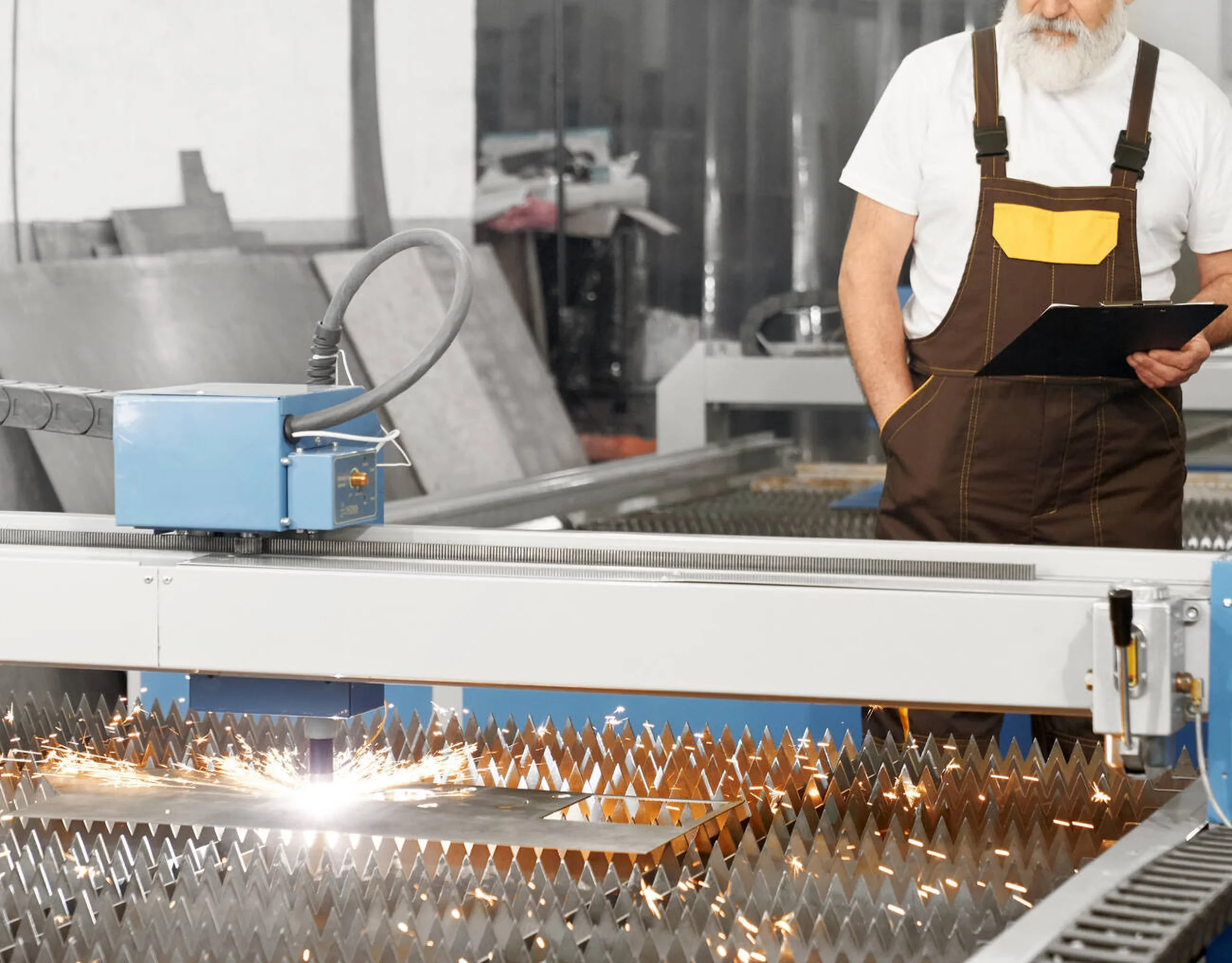 یک دستگاه برش لیزر فایبر CNC در حال برش یک ورق فلزی با سرعت بالا و جرقه‌های درخشان.